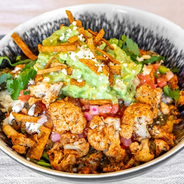 A Bar Bacoa taco bowl with roasted cauliflower, guacamole, pico de gallo, and tortilla strips.